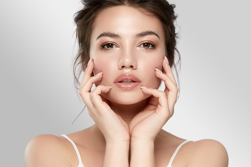 A woman holding her face showing a flawless skin from proven facial treatment... [a42962]