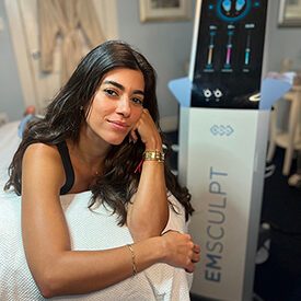 Beautiful young woman smiling while being treated at Blue Water Spa with Emsculpt.