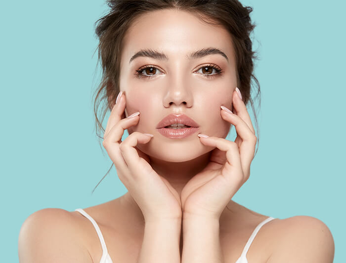 A woman touching her face showing her beautiful face. [8f6499]